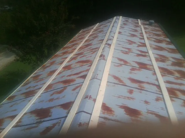 Rusted metal roof panels with new wood purlins before replacement — Storm Damage Roof Repair in Newbern by Roofing Brothers